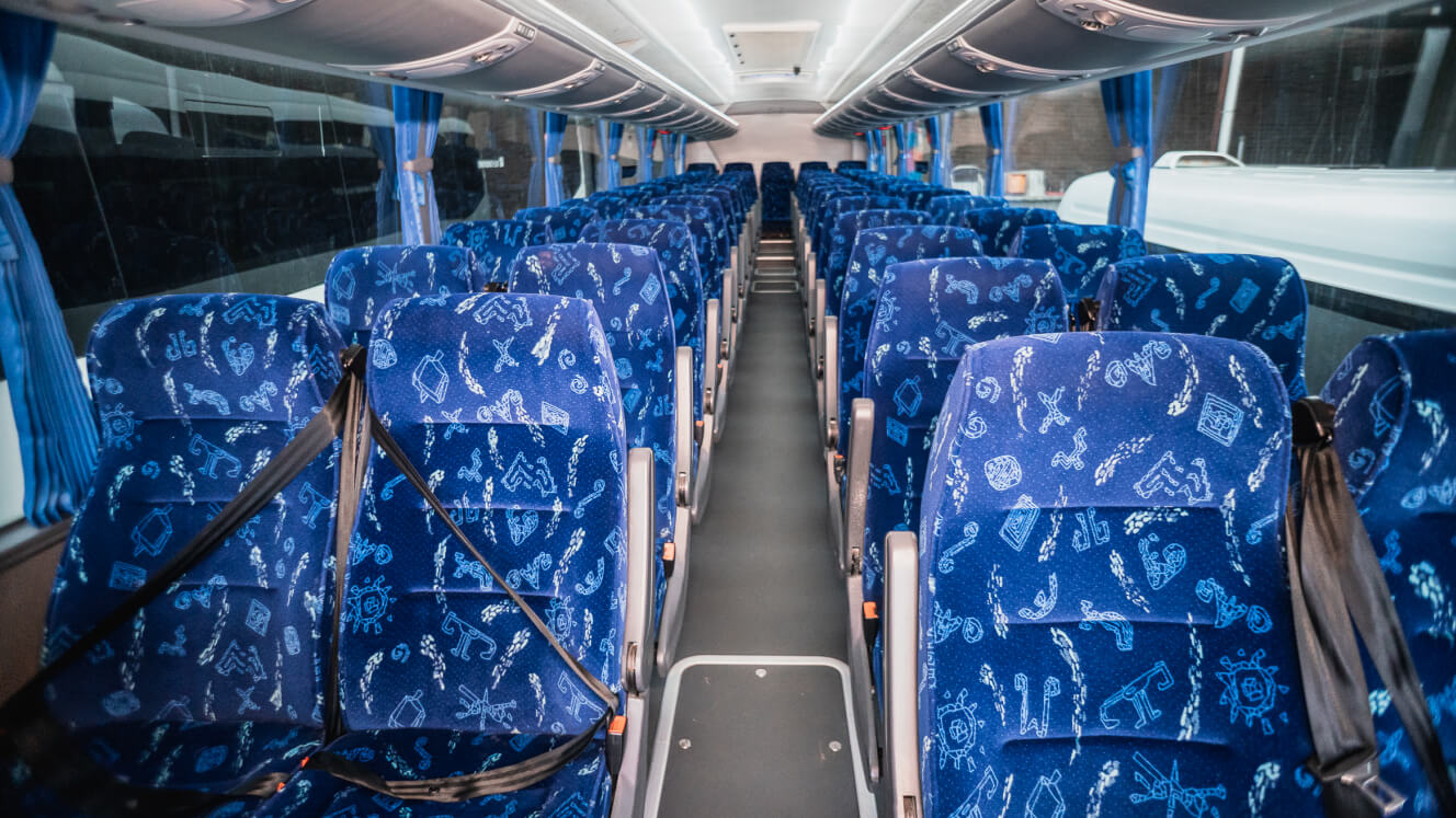 Clean coach interior with seatbelts fitted to passenger seats